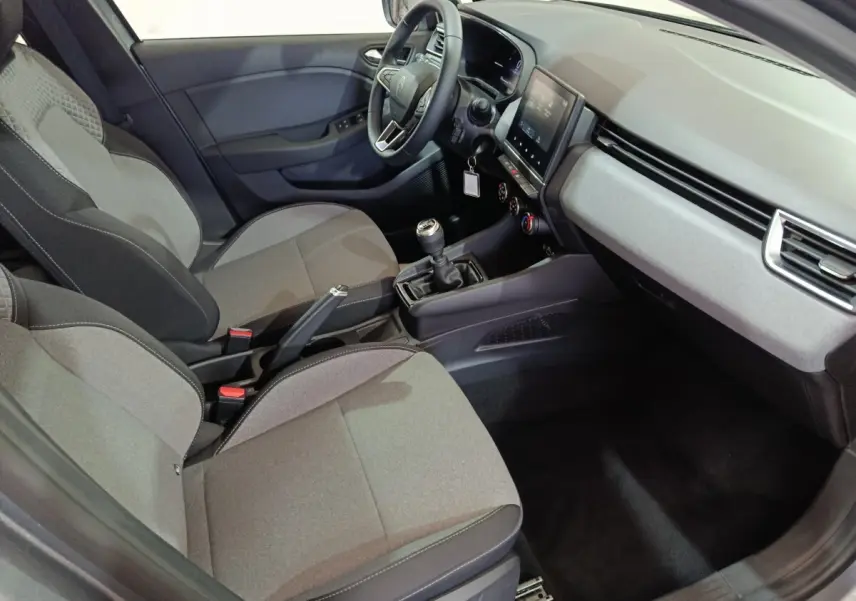 Vue intérieure côté conducteur de la Renault Clio gris clair 2025, avec volant multifonctions et écran tactile central.