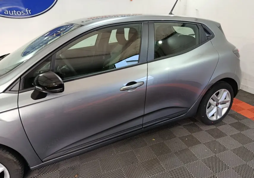 Profil côté gauche d'une Renault Clio gris clair 2025 Evolution Blue dCi 100 avec rétroviseur noir brillant.