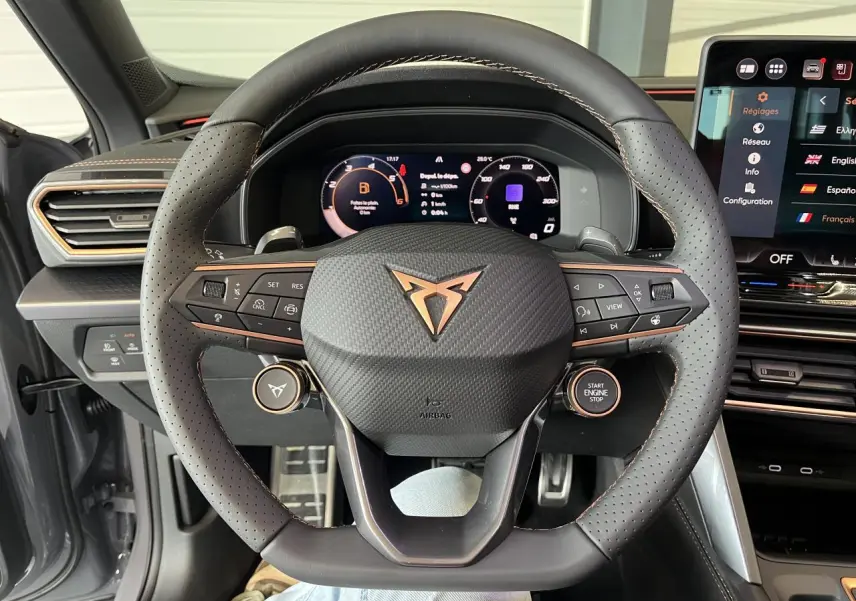 Vue intérieure centrée sur le volant perforé noir avec logo cuivre du CUPRA Formentor gris clair 2025.