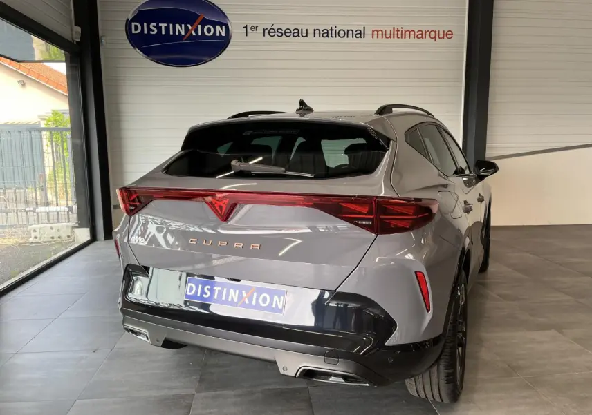 Vue 3/4 arrière droite du CUPRA Formentor gris clair avec signature lumineuse Tri-LED et double sortie d'échappement noire.