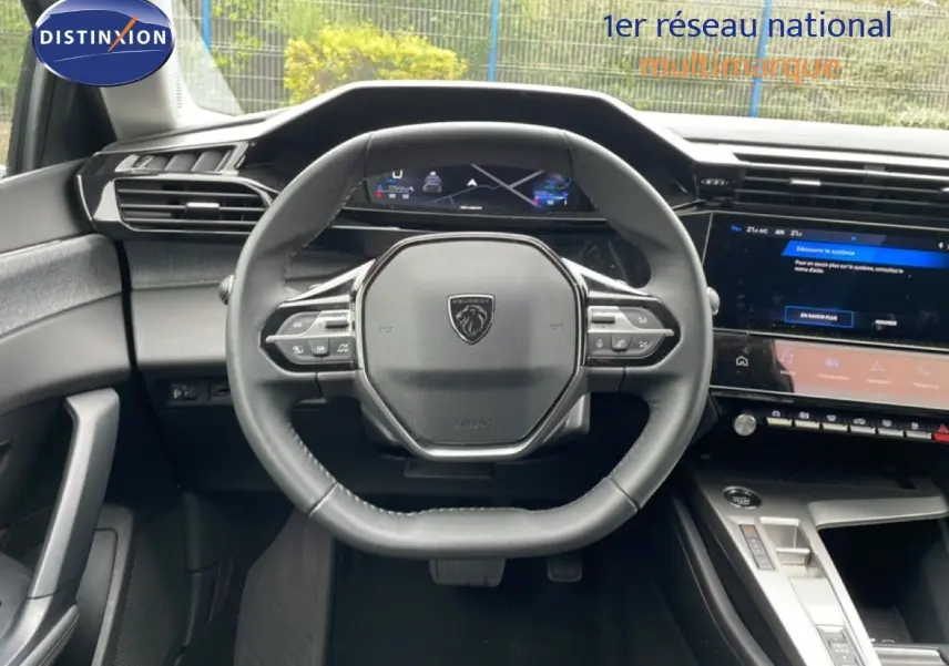 Vue intérieure centrée sur le volant cuir noir et le tableau de bord numérique de la Peugeot 408 gris selenium 2025.