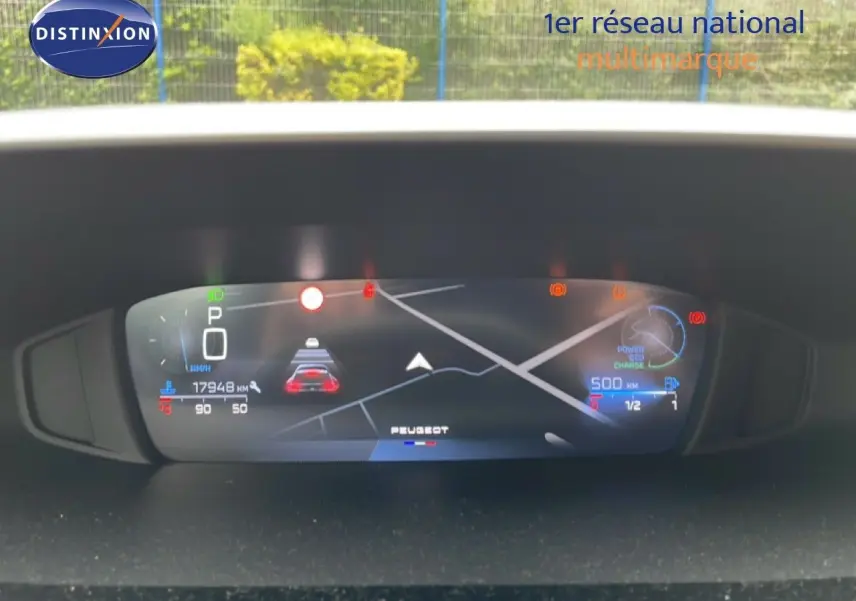 Tableau de bord numérique de Peugeot 408 gris, affichant la navigation et les alertes, vue frontale rapprochée.
