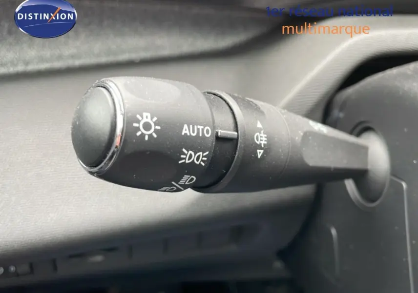 Gros plan sur la commande des phares du Peugeot 408 1.2 Hybrid 145ch, bouton noir avec symboles lumineux blancs.