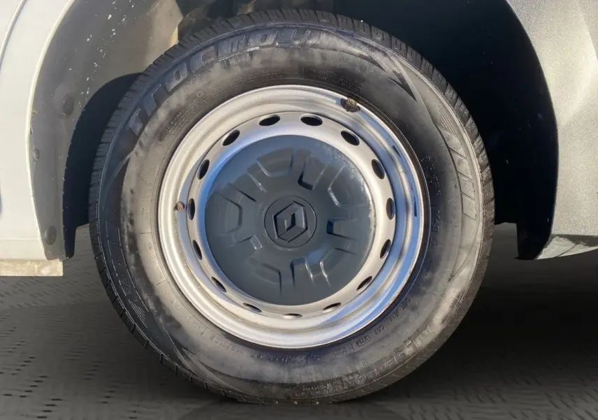 Gros plan sur la roue avant gauche du Renault Master blanc, jante acier avec enjoliveur marqué du logo Renault.