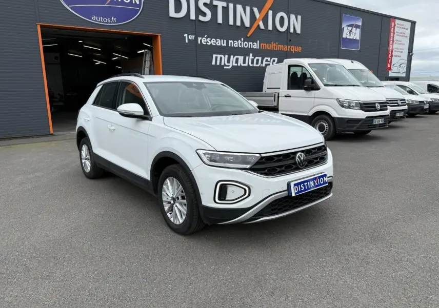 Volkswagen T-Roc blanc pur vu en 3/4 avant droit devant un garage Distinxion
