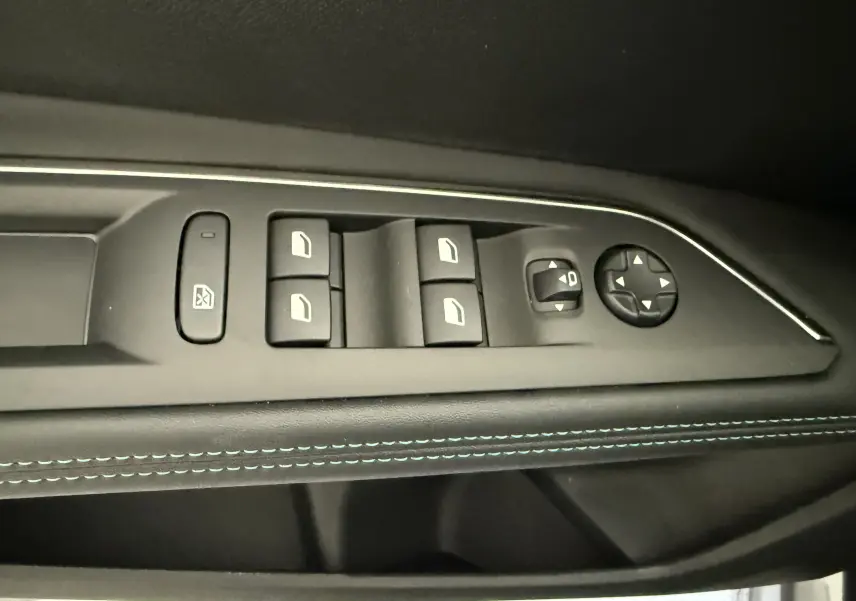 Panneau de commandes des vitres et rétroviseurs côté conducteur du Peugeot 3008 gris Artense 2023 avec surpiqûres bleues.
