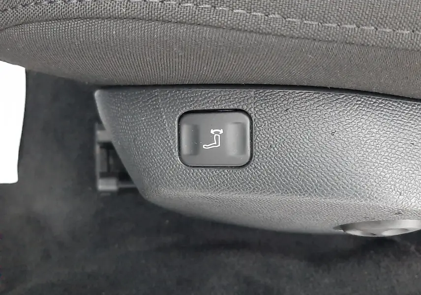 Bouton de réglage électrique de l'inclinaison du siège avant dans une Peugeot 508 blanche, version 1.5 BlueHDi 130 Active.