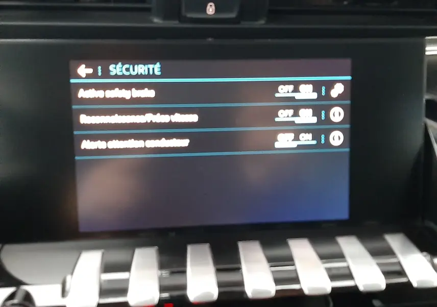 Vue rapprochée de l’écran tactile du tableau de bord de la Peugeot 508 blanc 2018, affichant le menu sécurité.