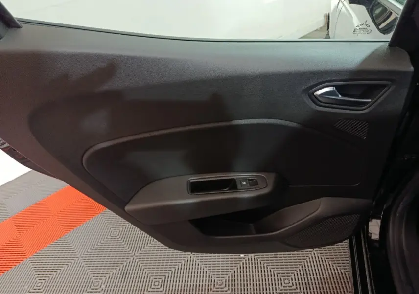 Vue intérieure de la porte arrière droite noire de la Renault Clio Evolution Blue dCi 100, avec poignée et commande de vitre électrique.