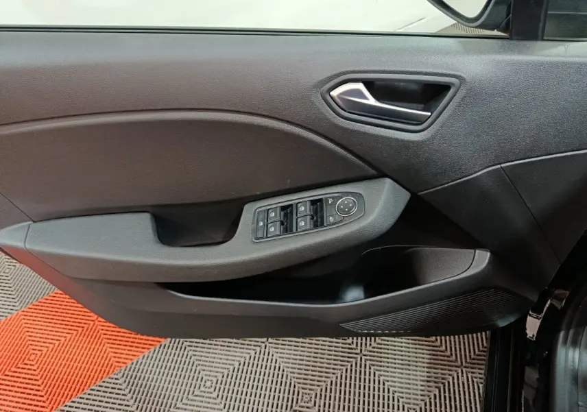Vue intérieure du panneau de porte avant gauche de la Renault Clio noire, avec commandes électriques des vitres et rétroviseurs.