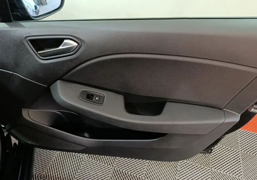 Vue intérieure du panneau de porte côté gauche de la Renault Clio noire, avec commande de lève-vitre électrique intégrée.