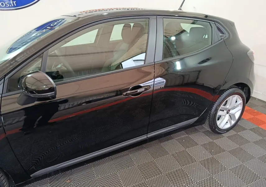 Profil côté gauche d'une Renault Clio noire 2025 avec jantes alliage et rétroviseurs noirs brillants.