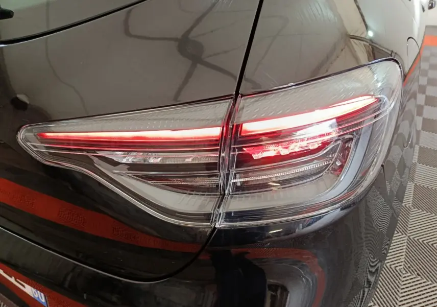 Gros plan sur le feu arrière droit allumé d'une Renault Clio noire Evolution Blue dCi 100 de 2025.