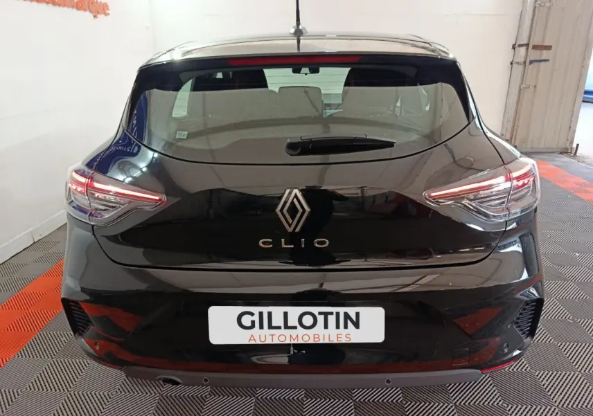 Vue arrière d'une Renault Clio noire 2025 avec feux LED allumés dans un garage.