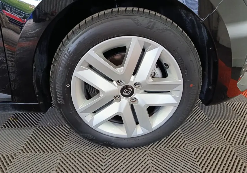 Gros plan sur la roue avant droite d’une Renault Clio noire 2025, avec jante argentée et pneu Bridgestone.