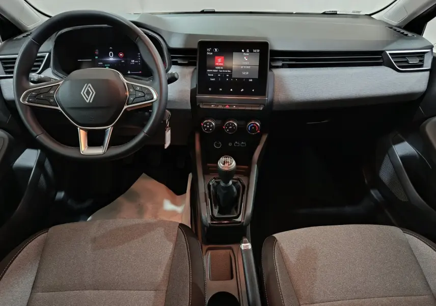 Vue intérieure avant de la Renault Clio Evolution Blue dCi 100 2025, tableau de bord gris avec écran tactile central et volant multifonctions.