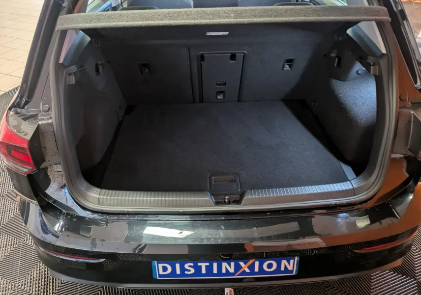 Coffre ouvert vu de l'arrière d'une Volkswagen Golf 1.5 eTSI noire 2024, montrant un espace de chargement propre et spacieux.