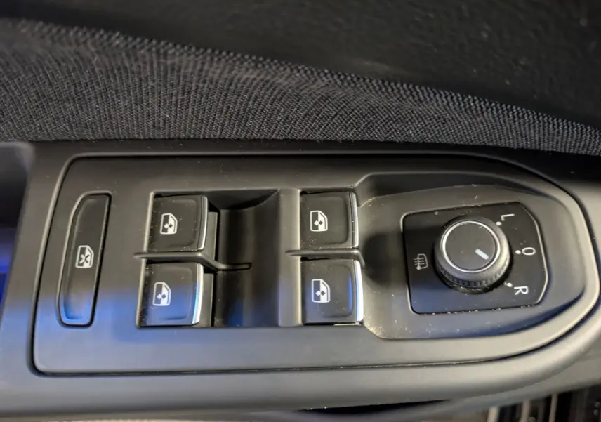 Commande des vitres électriques et réglage des rétroviseurs côté conducteur d'une Volkswagen Golf 2024 noire.
