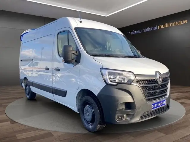 Vue 3/4 avant droite d’un Renault Master blanc 2022 avec calandre noire et feux LED, stationné en intérieur showroom.