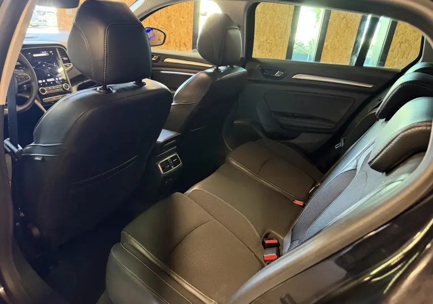 Vue intérieure arrière droite de la Renault Mégane Estate 2024 noire, montrant les sièges en cuir et les aérateurs arrière.