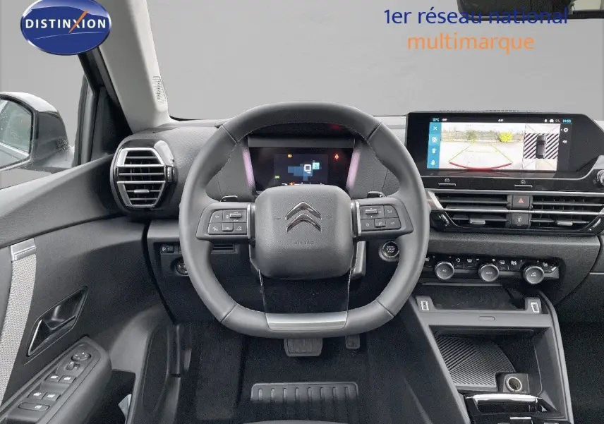 Intérieur de la Citroën C4 2024 en gris platinium, vue frontale du volant et tableau de bord avec écran tactile et caméra de recul.
