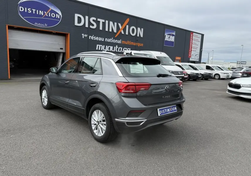 Volkswagen T-Roc gris Indium métal vu en 3/4 arrière droit sur parking devant concession Distinxion.