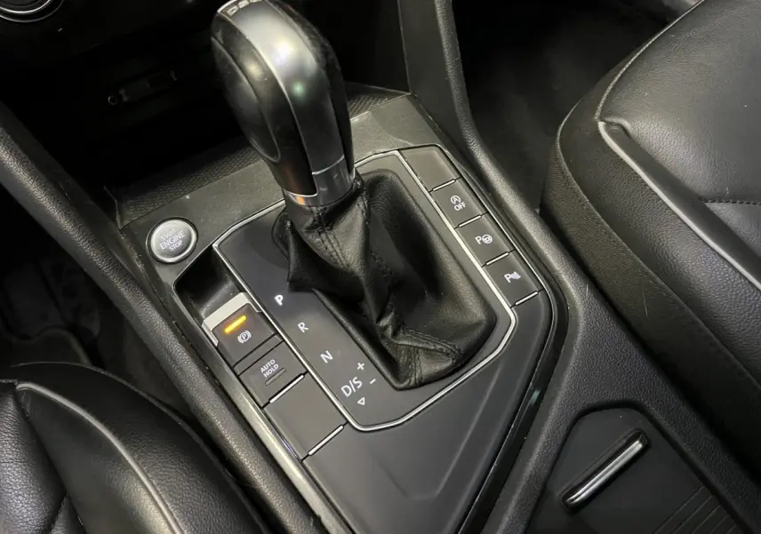 Le levier de vitesses automatique noir du Volkswagen Tiguan 2017 vu de dessus avec sièges en cuir noir.
