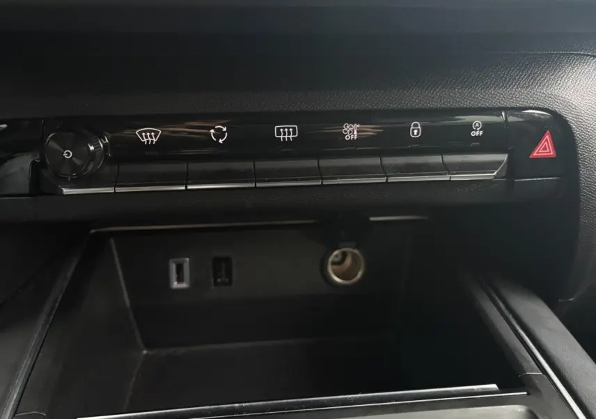 Vue rapprochée de la console centrale noire du Citroën C5 Aircross Hybrid 2024, avec commandes et prises USB visibles.