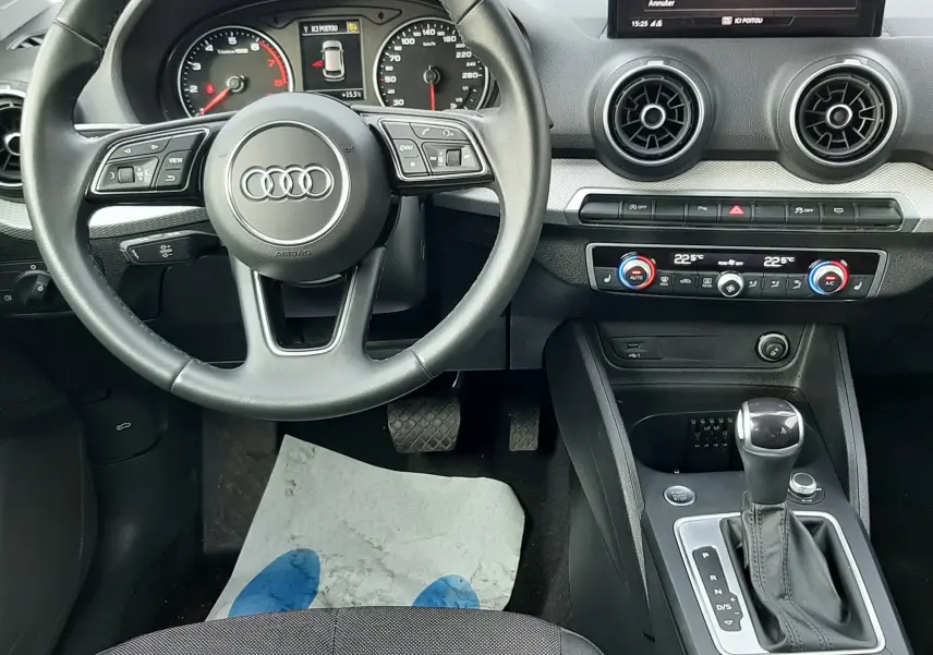 Vue intérieure de l'Audi Q2 35 TFSI 2023 montrant le volant, tableau de bord et console centrale avec boîte auto.