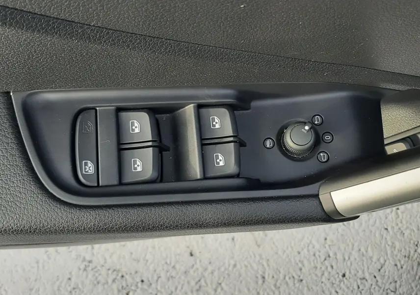 Commande des vitres électriques et réglage des rétroviseurs sur la porte côté conducteur d'un Audi Q2 noir Mito Metal 2023.