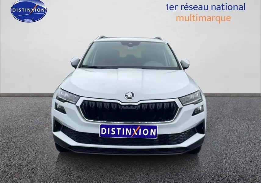 Vue frontale d'un Skoda Karoq blanc glacial avec calandre noire et phares LED distinctifs.
