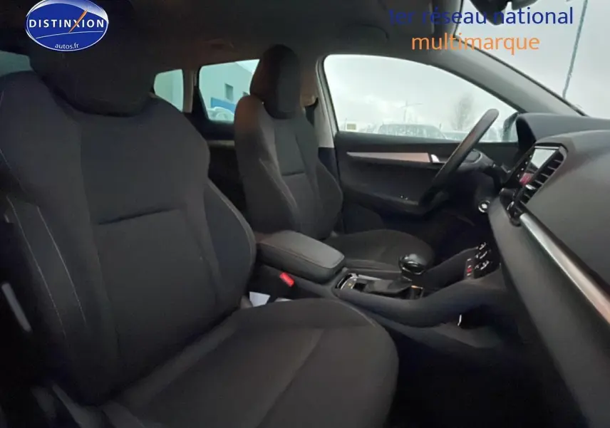 Intérieur noir du Skoda Karoq 1.5 TSI 2025 vu côté conducteur, avec console centrale et volant multifonction.