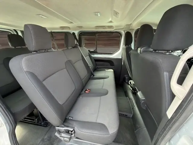 Vue intérieure côté gauche du Renault Trafic Fourgon gris clair 2022, montrant la banquette arrière 3 places et les sièges avant.