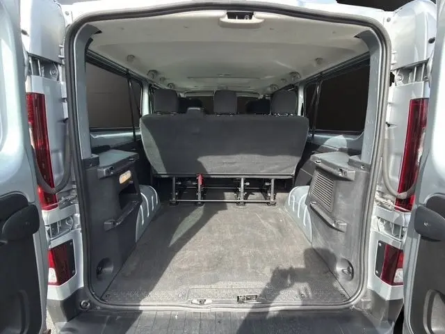 Vue arrière ouverte du Renault Trafic Fourgon gris clair 2022, montrant l'espace de chargement et la troisième rangée de sièges rabattables.
