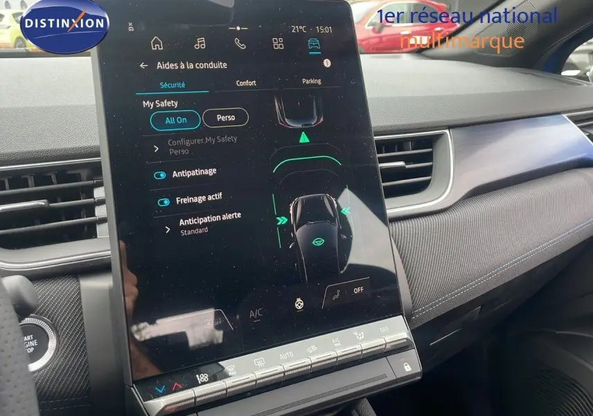 Vue rapprochée de l'écran tactile central du Renault Captur E-Tech Hybrid 2025, intérieur gris avec détails bleus.