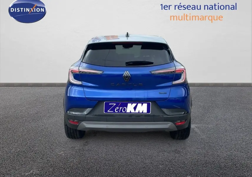 Vue arrière d'un Renault Captur bleu Iron Metal avec toit gris, version hybride E-Tech 2025, sur fond neutre.