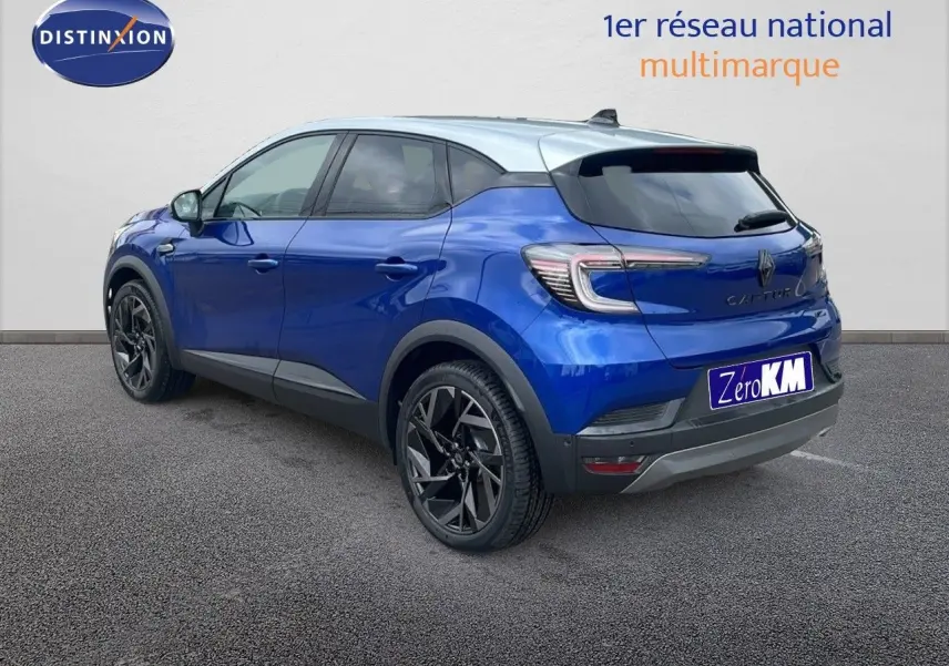 Renault Captur E-Tech hybride bleu Iron avec toit gris, vue 3/4 arrière côté gauche, jantes noires distinctives.