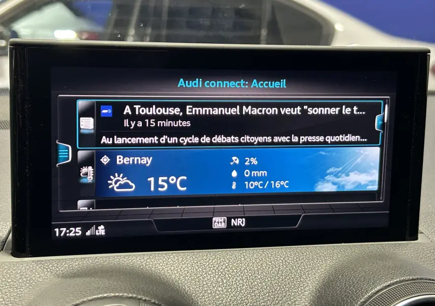 Gros plan sur la console centrale de l'Audi Q2 35 TFSI 2023, montrant les commandes de climatisation digitale et les voyants actifs.