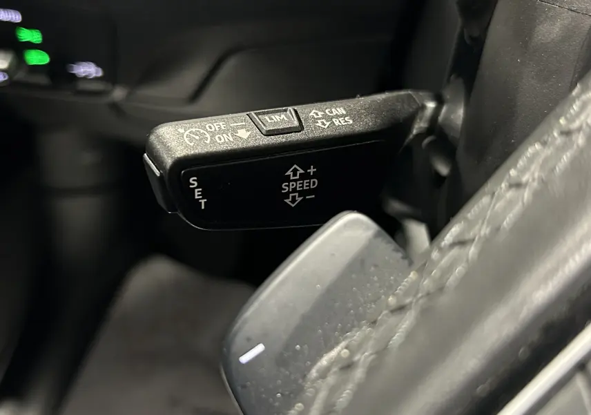 Le commodo de clignotants et feux sur le côté gauche du volant d'un Audi Q2 noir métal 2023.