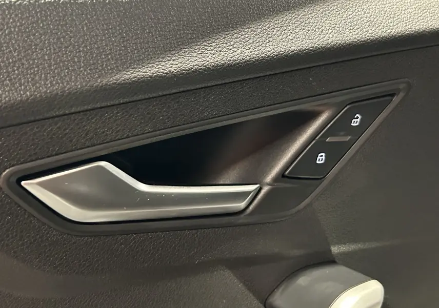 Panneau de commandes des vitres et rétroviseurs côté conducteur d’un Audi Q2 noir métal 2023.