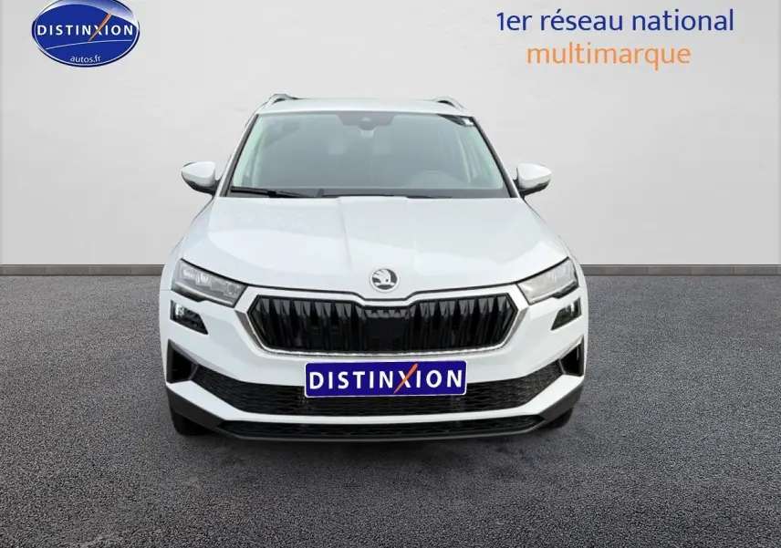 Vue frontale d'un SKODA KAROQ blanc glacial avec calandre noire et phares LED distinctifs.