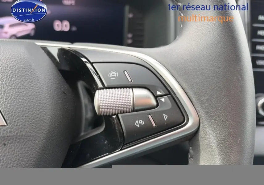 Gros plan sur les commandes multifonctions en cuir du volant du Skoda Karoq blanc glacial, version 2025.