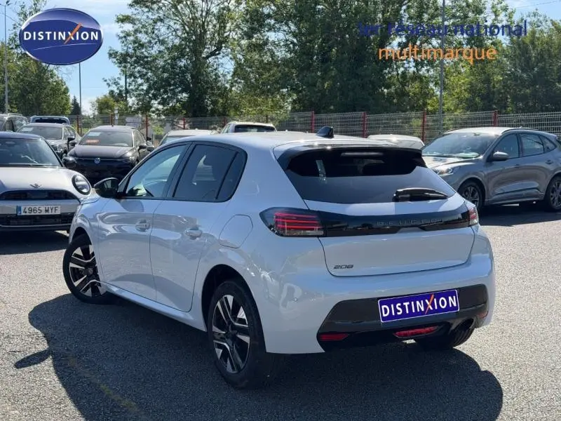 Vue 3/4 arrière droite d'une Peugeot 208 blanche Okénite avec feux arrière LED et jantes alliage noires.
