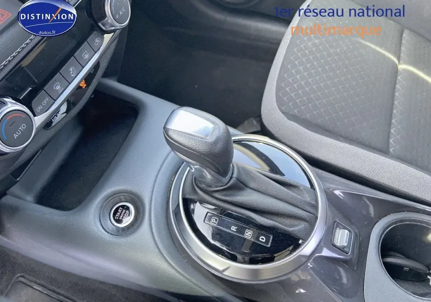Le levier de vitesses automatique et le bouton start/stop du Nissan Juke gris clair vus de dessus côté console centrale.
