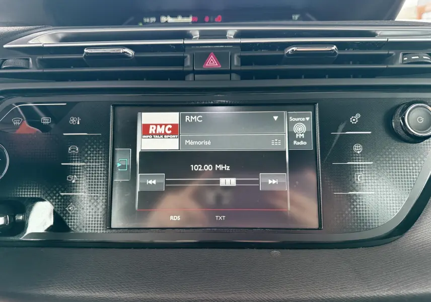Vue rapprochée de l’écran multimédia central de la Citroën C4 Picasso gris platinium, affichant la radio sur 102.00 MHz.
