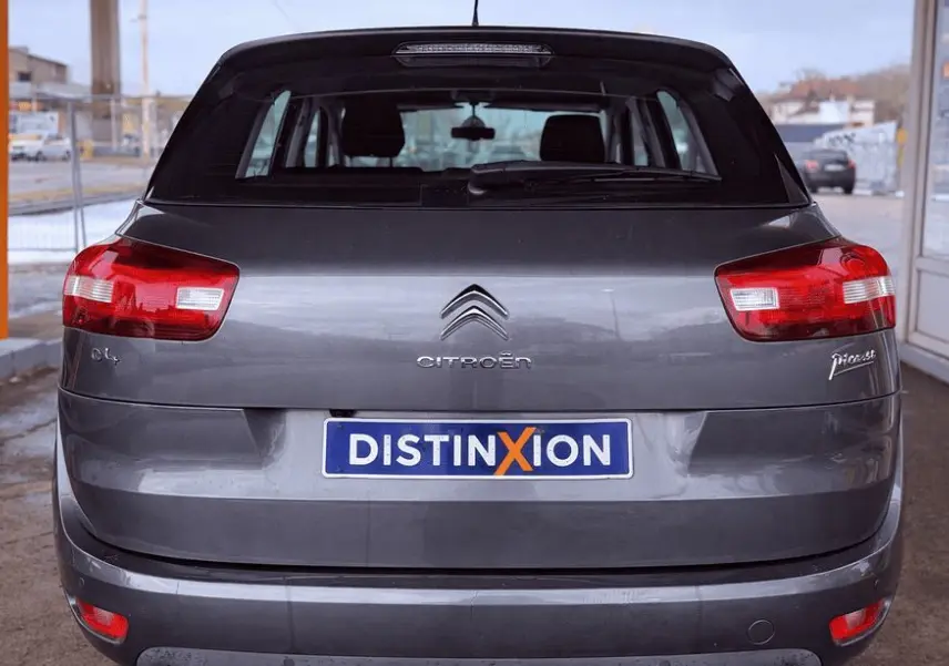 Vue arrière d'une Citroën C4 Picasso gris platinium métallisé avec feux rouges et plaque d'immatriculation Distinxion.