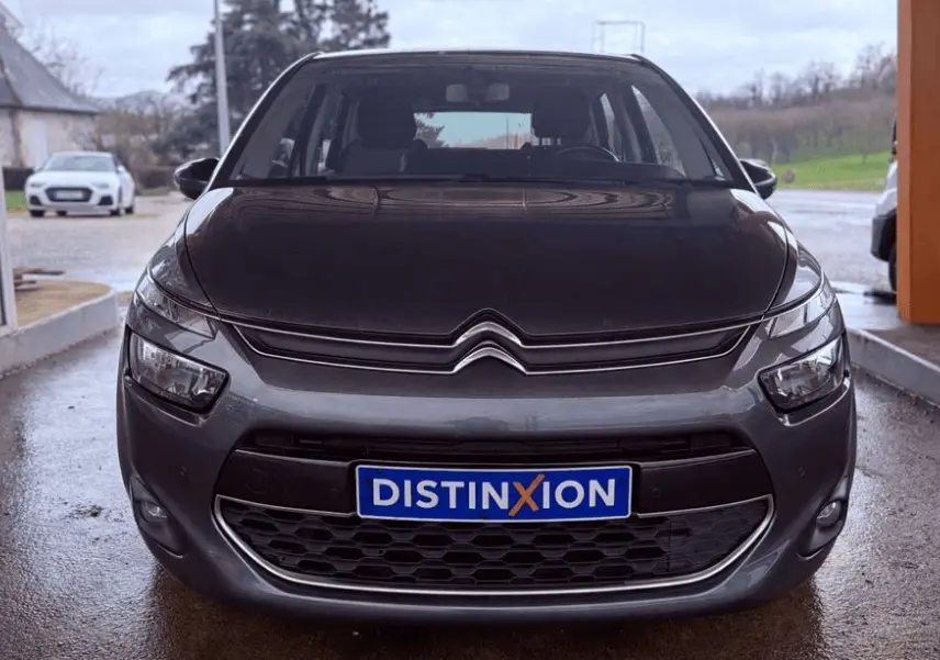 Vue frontale d'une Citroën C4 Picasso gris platinium métal avec calandre et logo distinctifs visibles.