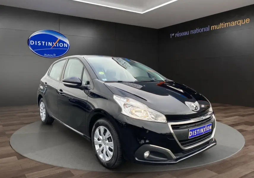 Peugeot 208 Affaire noir vue 3/4 avant droit, phares allumés, sur plateau en showroom Distinxion.