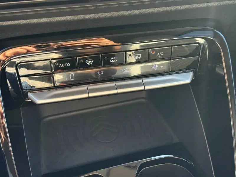 Gros plan sur la commande de climatisation automatique noire brillante du Citroën C3 2025 avec écran digital et boutons tactiles.