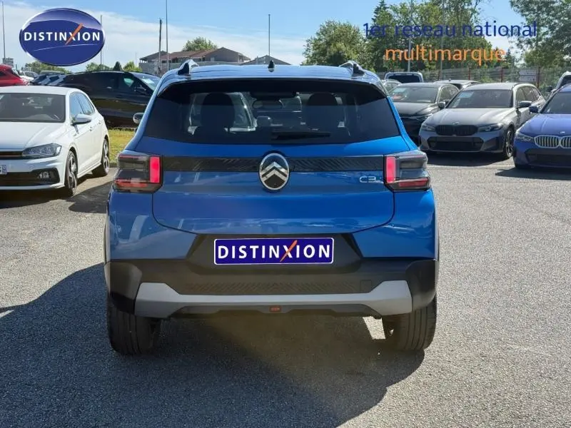 Vue arrière d'une Citroën C3 2025 Bright Blue avec toit noir Perla Nera, feux arrière LED et logo centré.